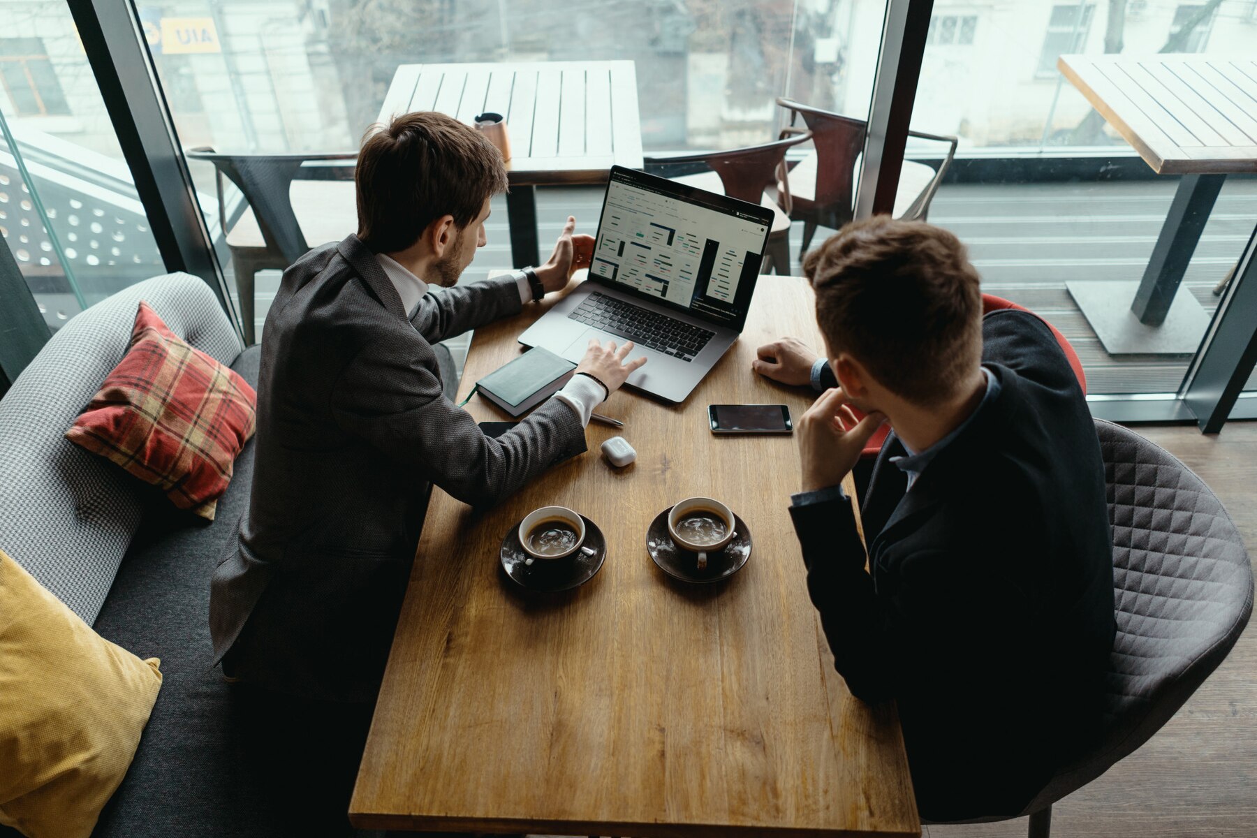 two-young-businessman-having-successful-meeting-restaurant_158595-5246